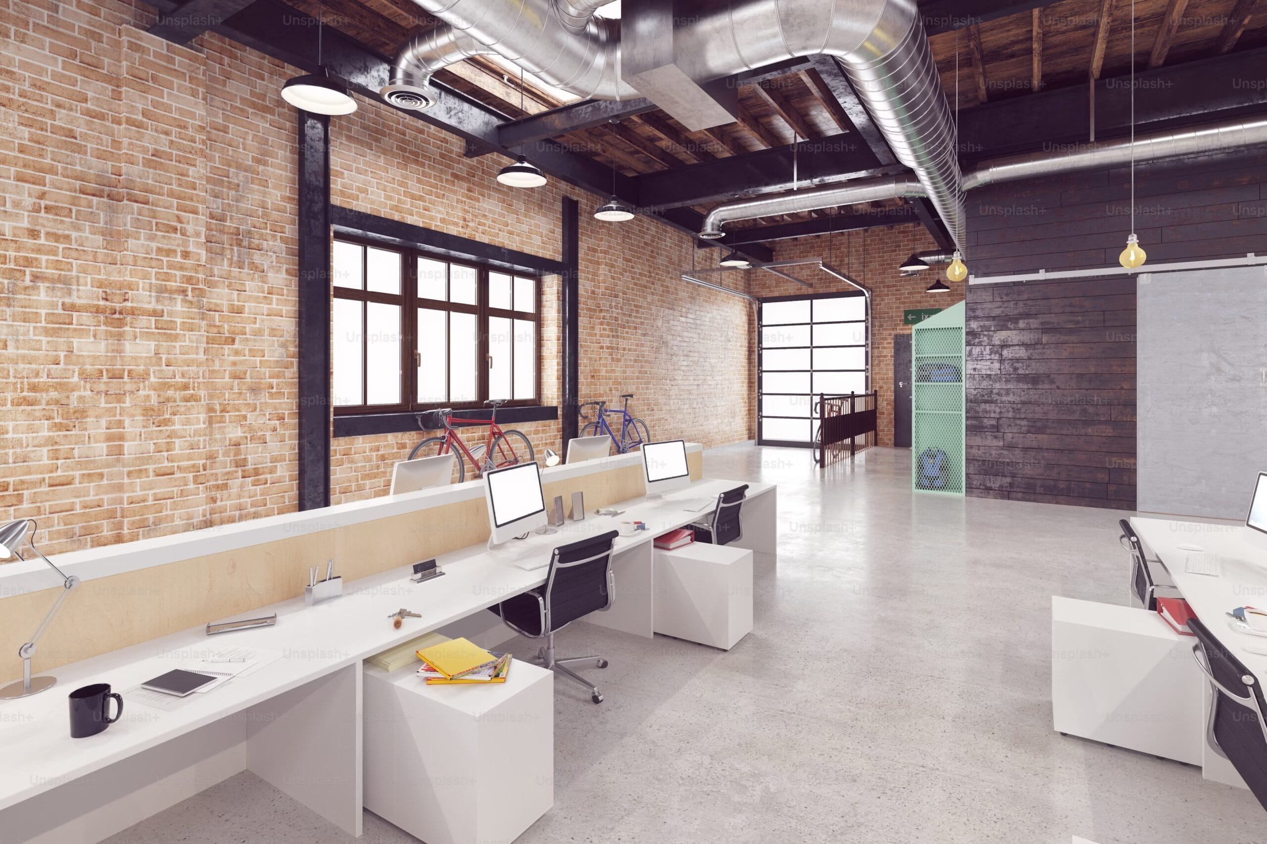 Un ufficio elegante con pareti di mattoni e scrivanie ordinate, ideale per un ambiente di lavoro creativo e dinamico.